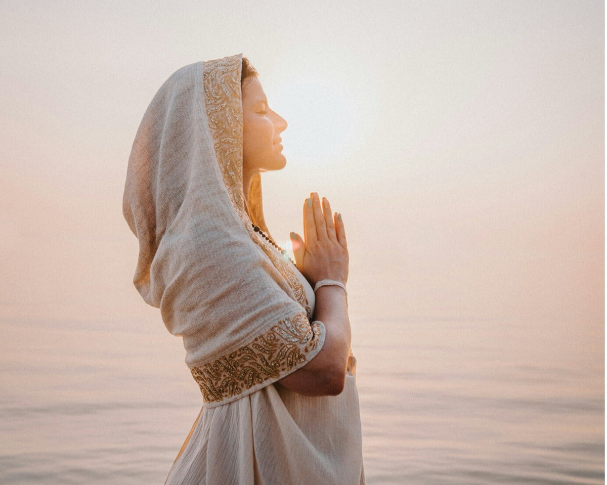 Woman praying by the sea